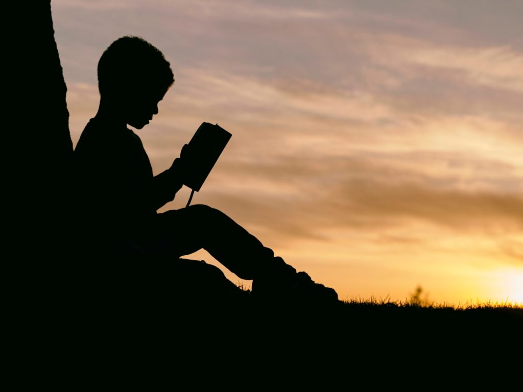 Kid learning a book about how to develop executive presence using stories