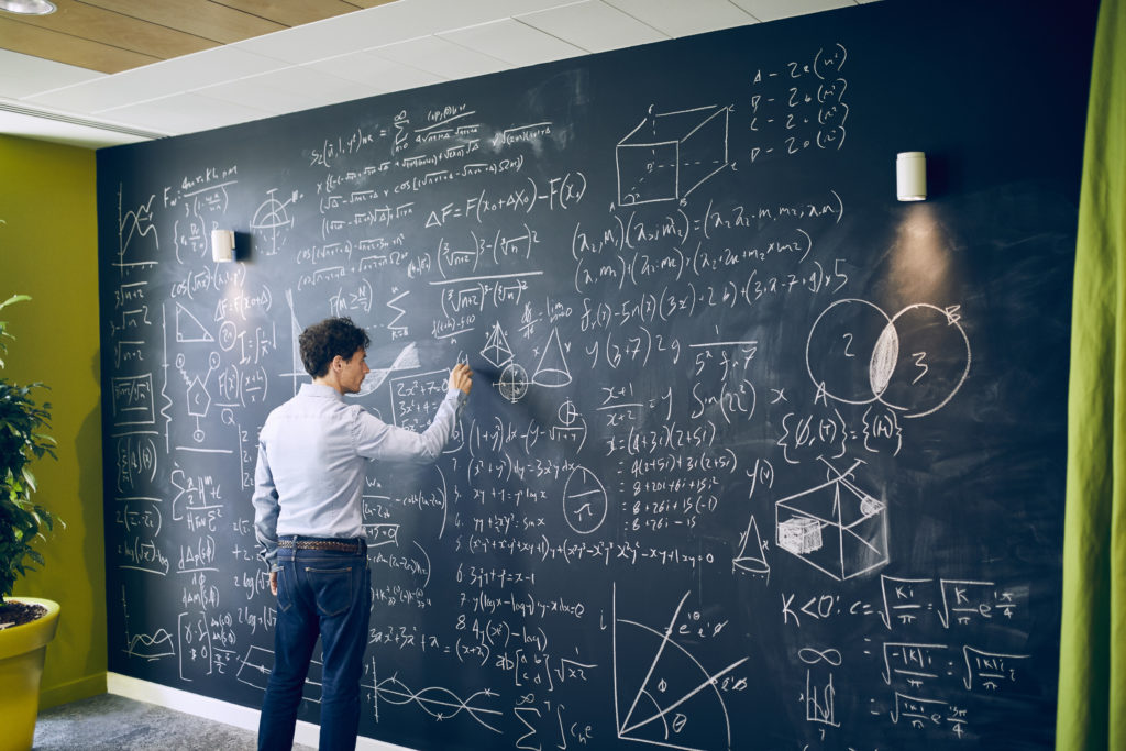 Teacher explaining on black Board how critical thinking can help